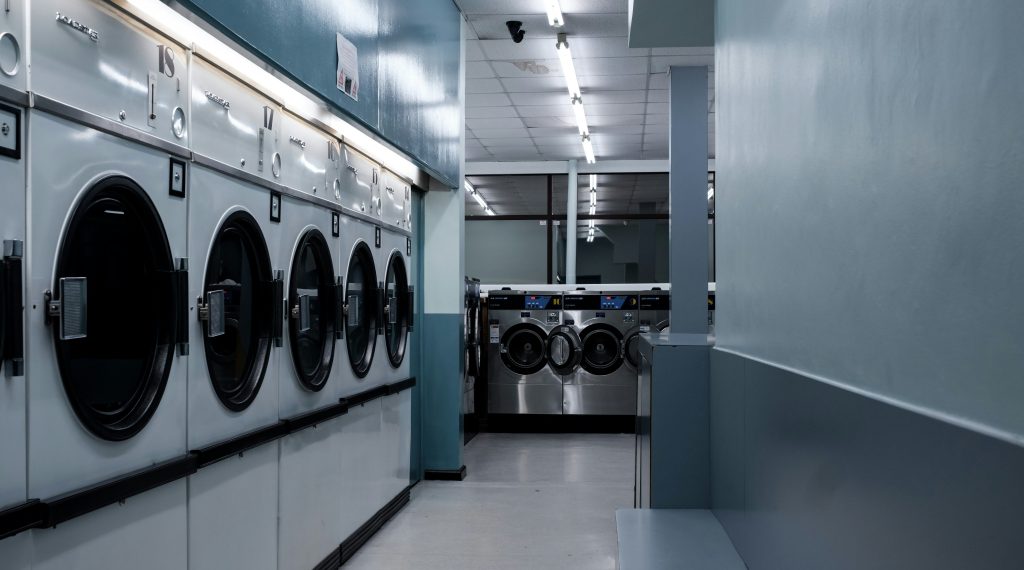Rows of washers and dryers inside a clean, bright laundromat